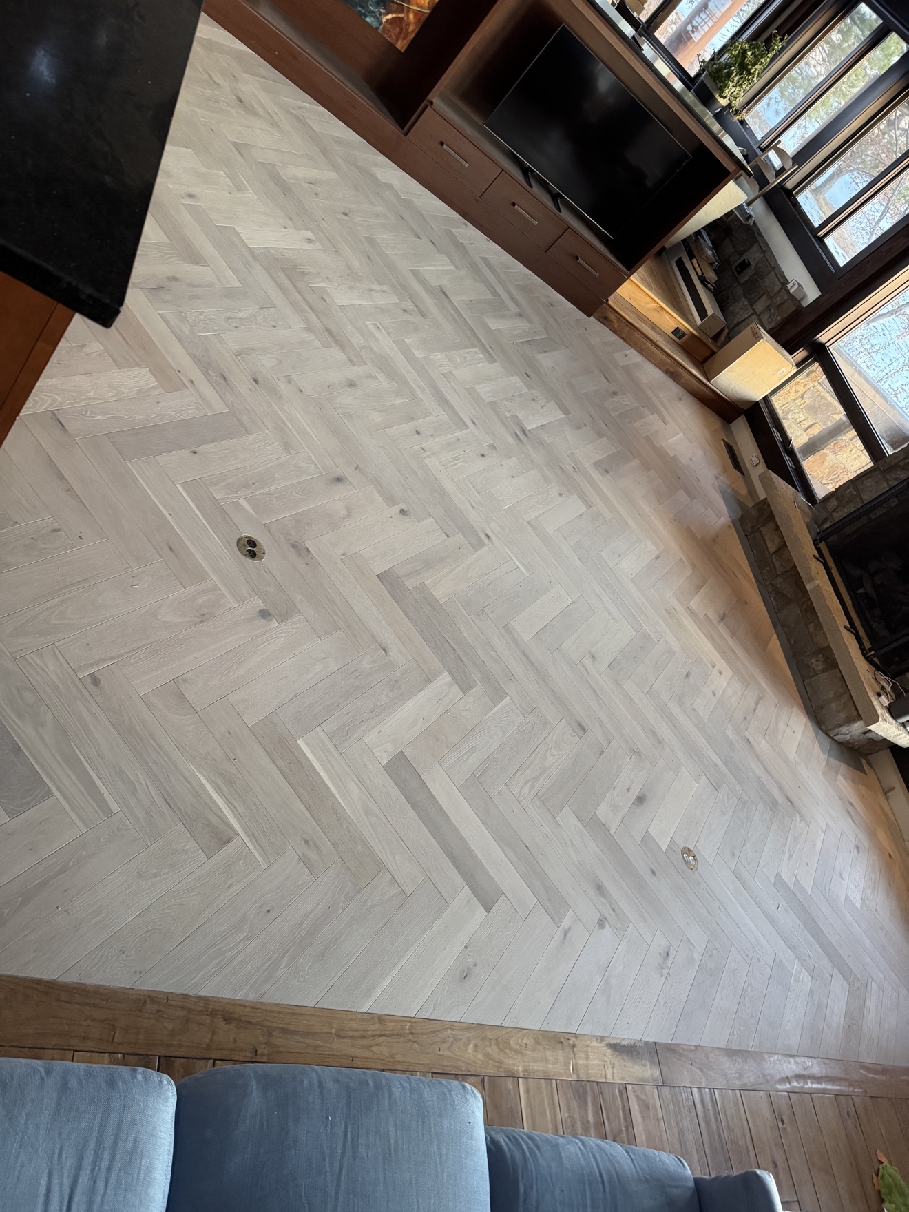 Custom herringbone wood floor extending through a residential living room