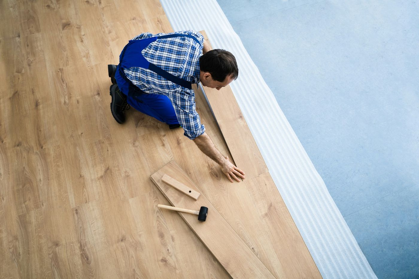Installer aligning floor planks
