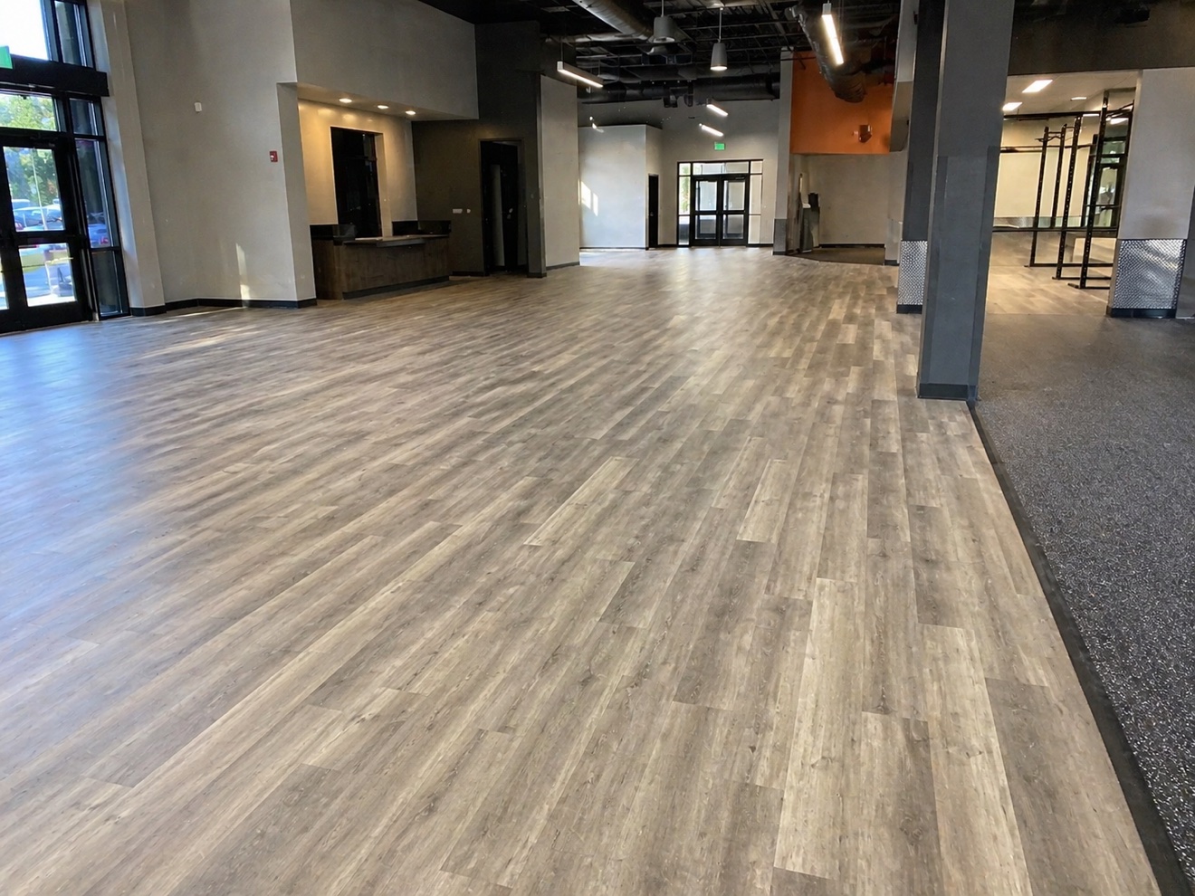 Finished gray wood-look glue-down LVP in a spacious commercial lobby