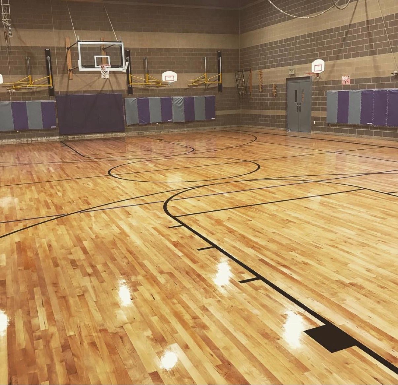 Professionally refinished wood sports court with crisp game lines