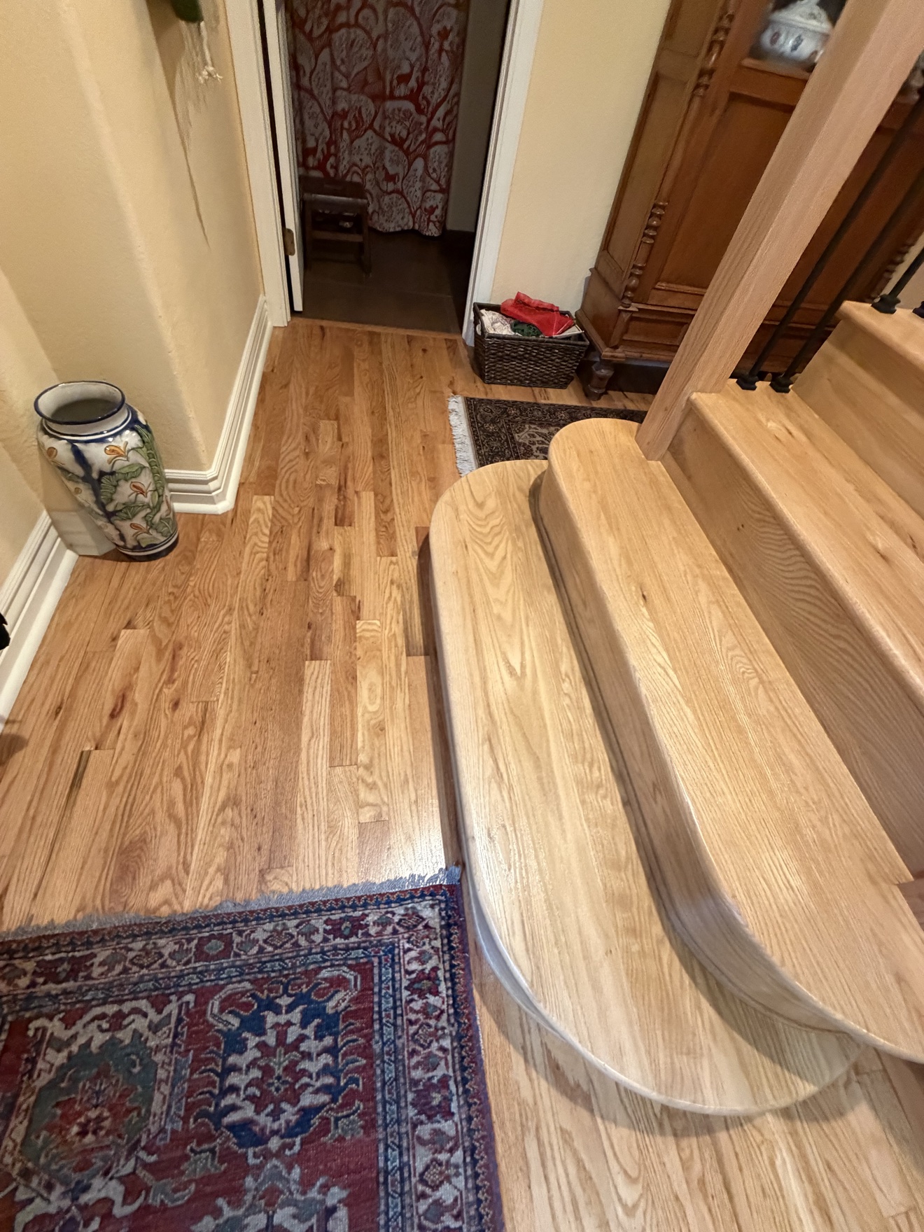 Custom curved wood staircase detail at a residential entry